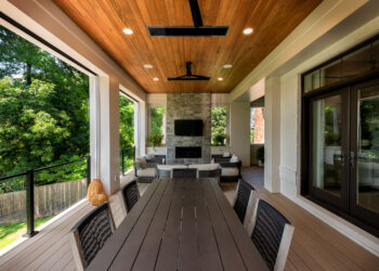 Open-air dining porch with wood ceiling and stone fireplace