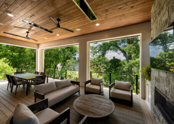 Spacious outdoor living room with fireplace dining zone and ceiling fans