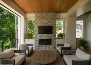 Wood-ceiling porch lounge with fireplace and canopy views