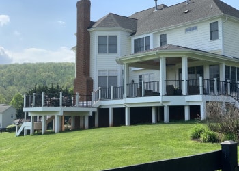Custom wood deck with covered porch and a view across the property.