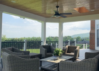 Custom deck seating area with wood ceiling and ceiling fan.