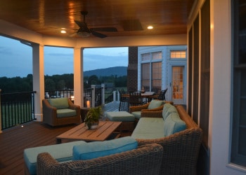 Twilight view of covered porch lounge and deck.