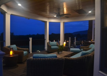 Night view of covered outdoor seating and deck lighting.