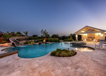 Twilight view of the freeform pool waterslide spa and pavilion at Sliding into Relaxation