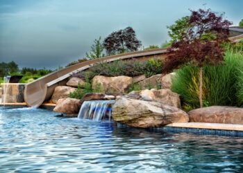 Rock waterfall and waterslide detail along the freeform pool