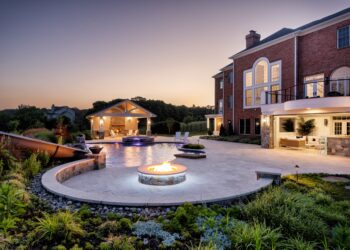 Twilight overview of the pool waterslide fire feature and pool house