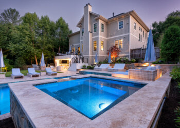 Twilight overview of the terraced pool spa fire bowls and multi-level outdoor living space