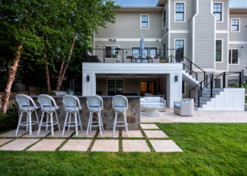 Outdoor dining deck overlooking the pool and layered terrace