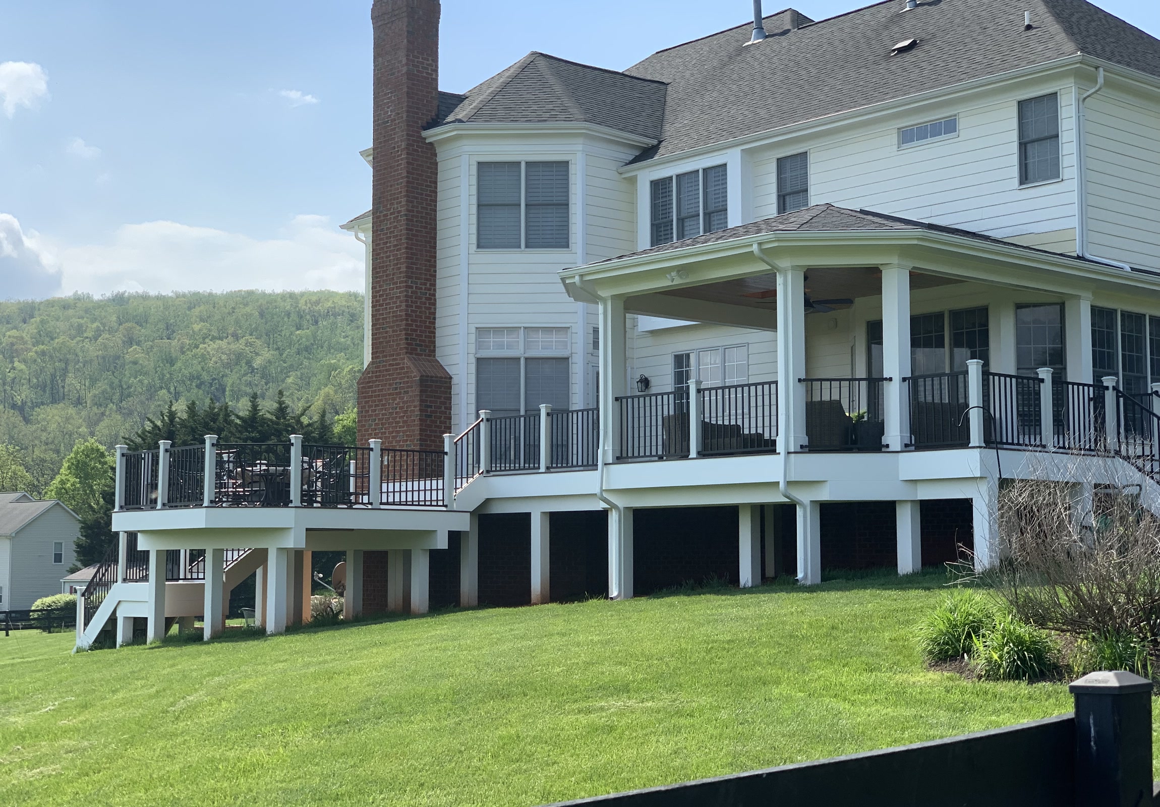 Custom wood deck with covered porch and a view across the property.